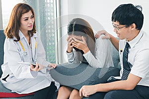 Young Asian male doctor consulting patient in hospital office. Infertility problem with marriage couple concept