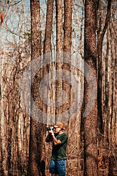 Young asian male photographer with casual cloth in forest travel