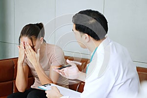 Young Asian male psychiatrist is specialist in psychiatry is advicing and listening to problems of Caucasian female Patient.