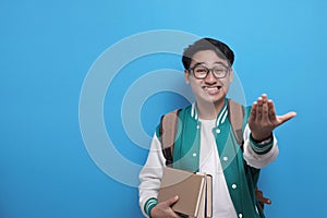 Young Asian male student smiling and do calling gesture with hand, marketing concept