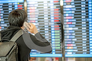 Young asian man with backpack bag checking his flight