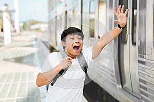 Young asian man with backpack running to catch the train