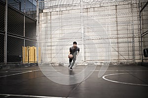 Young asian man basketball player attempting a dunk outdoors