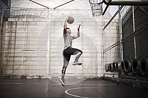 Young asian man basketball player attempting a dunk outdoors