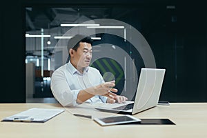 A young Asian man conducting online business training. Sitting in the office online from a laptop