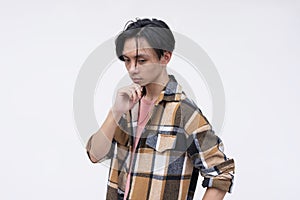 A young asian man deliberating on his next move. Strategist thinking, chin on his hand. Isolated on a white background