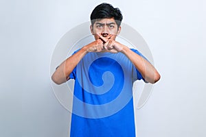 Young asian man doing rejection expression crossing fingers doing negative sign