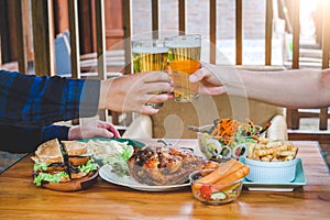 Young asian man drinking beer and clink glasses happy while enjoying home party