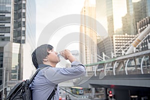 Young Asian man drinking a bottle of water