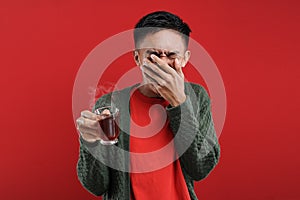 Young Asian man drinking a cup of bad tea, bitter tea