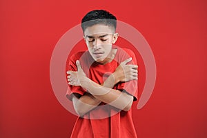 Young Asian man feel dizzy and feverish, isolated on red photo