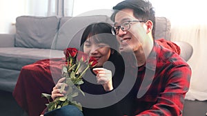 Young asian man giving red roses to his girlfriend. Happy valentines day