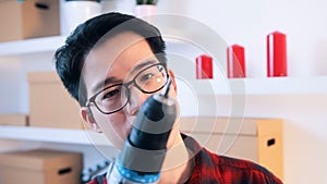 Young asian man with glasses holding drill