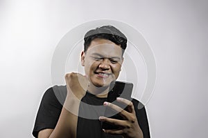Young asian man happy expression and holding smartphone on white background