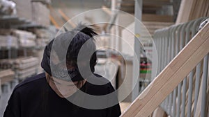 Young Asian man in a hardware store. Portrait of a buyer in a building supermarket