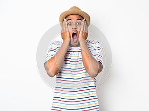Young Asian man with hat feels shock and surprise with overly face expression.