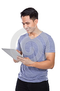 Young Asian man holding a digital touch screen tablet computer o