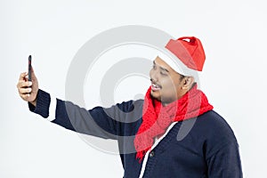 Young Asian man holding smartphone and taking selfie photo