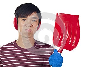 Young Asian man holding snow shovel