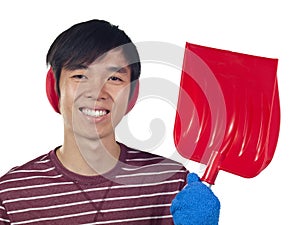 Young Asian man holding snow shovel