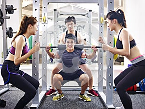 Young asian man lifting weight in gym