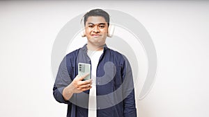 Young Asian man listening to music using wireless headphones
