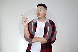 Young Asian man looked happy thinking and looking up, having good idea. Half body portrait against white wall