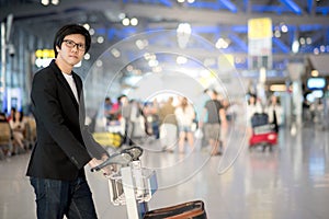 Young asian man with luggage in airport terminal