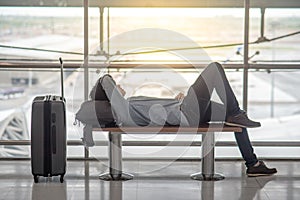 Joven asiático hombre acostada sobre el bancos en aeropuerto 