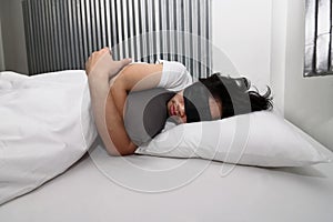 Young Asian man with mask comfortable sleeping on the bed in home.