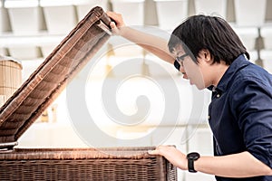 Young Asian man opening wooden box looking inside