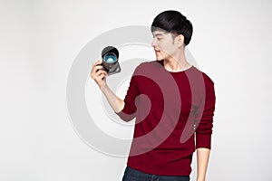 Young Asian man photographer holding camera isolated on white background