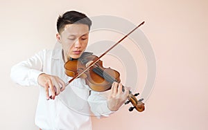 Young Asian man play violin. Classical music instrument. Art and music portrait background with copy space.