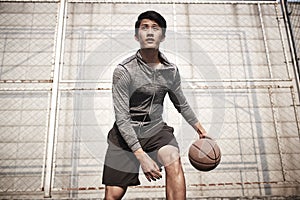 Young asian man playing basketball