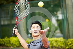 Young asian man playing tennis