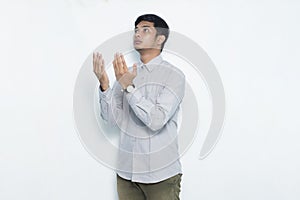 Young asian man praying isolated on white background