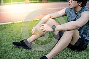 Young Asian man runner drinking energy drink after running in th