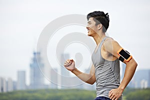 Young asian man running in park