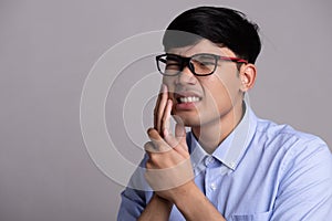 Young asian man with sensitive teeth or toothache. Healthcare concept