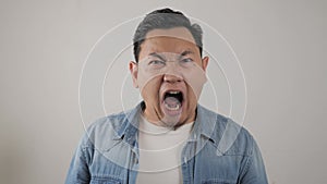 Young Asian man shouting loud because of anger. Concept of rage aggression mad frustration