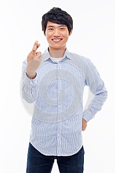 Young asian man showing lucky sign.