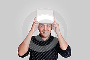 Young Asian Man Showing Small Whiteboard Covering His Head