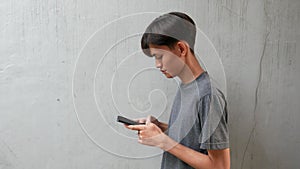 young asian man texting, is replying to a message from a friend