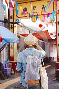 Young Asian man traveler and photographer with jean shirt and hat taking photos