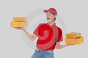 Young asian man in uniform red and cap standing carrying box stack with excited isolated.