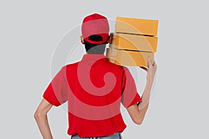 Young asian man in uniform red and cap standing carrying box stack isolated white background.