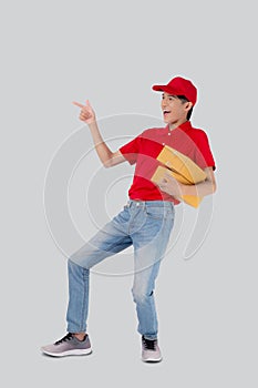 Young asian man in uniform red and cap standing carrying box stack isolated white background.