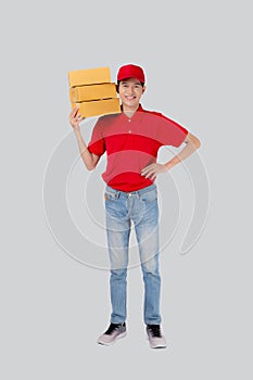 Young asian man in uniform red and cap standing carrying box stack isolated white background.