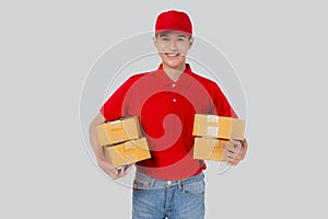 Young asian man in uniform red and cap standing carrying box stack isolated white background.