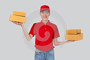 Young asian man in uniform red and cap standing carrying box stack isolated white background.